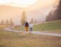 woman in black jacket and white pants walking on road during daytime