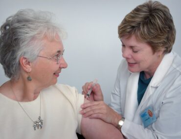 woman inject a woman on left shoulder