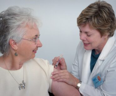 woman inject a woman on left shoulder